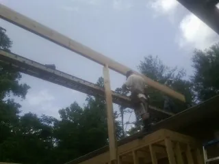 Carpenter setting a ridge beam over a new addition frame — Ice Dam Removal by Roofing Brothers in Adams